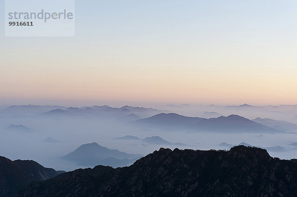 Morgenstimmung  Nebel  bizarr aufragende Felsen und Berge  Silhouette  Huang Shan  Mount Huangshan  Provinz Anhui  Volksrepublik China
