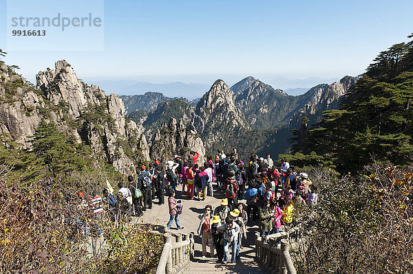 Chinesische Touristen stehen am Aussichtspunkt  felsige Berglandschaft  Huang Shan  Mount Huangshan  Provinz Anhui  China  Asien