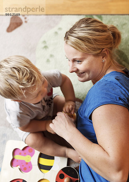 Hochwinkelansicht der Mutter beim Spielen mit dem Baby zu Hause