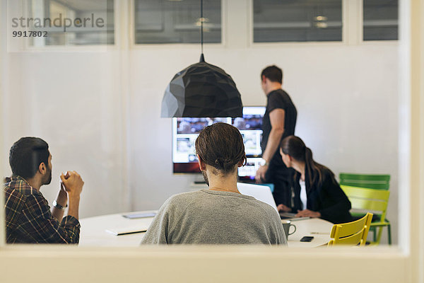 Kreative Geschäftsleute bereiten sich auf eine Videokonferenz im Sitzungssaal vor.