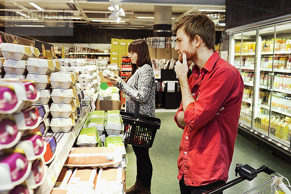 Mann und Frau beim Einkaufen im Supermarkt