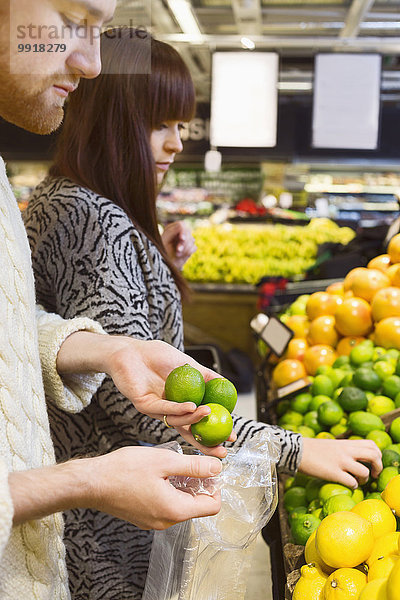 Junges Paar wählt Früchte im Supermarkt aus