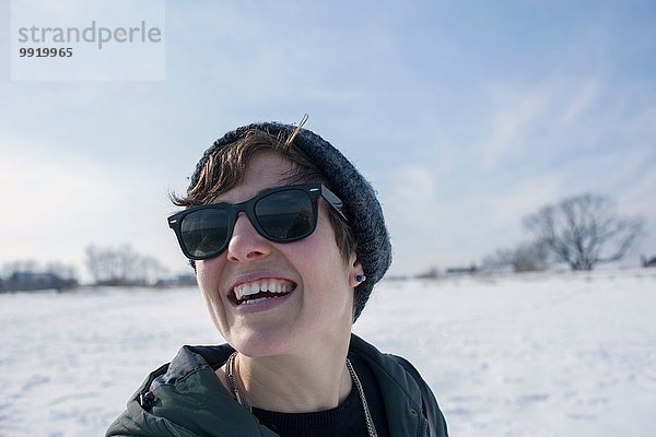 Porträt einer mittleren erwachsenen Frau  lachend  vor verschneiter Kulisse