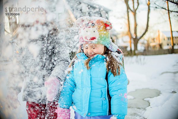 Mädchen spielen mit Schnee