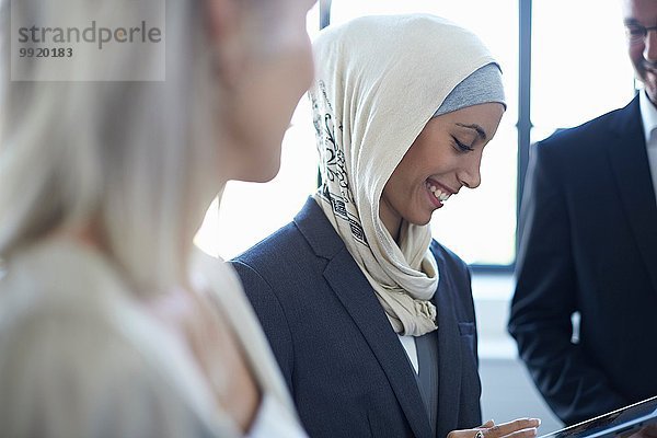 Blick über die Schulter auf Geschäftsfrauen und Männer im Büro