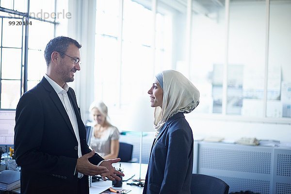 Der reife Geschäftsmann im Gespräch mit der jungen Geschäftsfrau im Amt