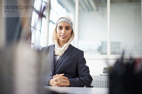 Porträt einer jungen Geschäftsfrau mit Hijab am Schreibtisch