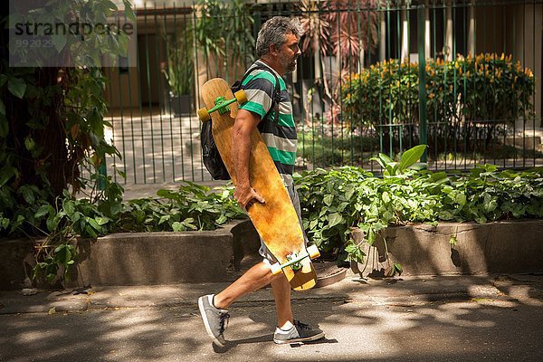 Erwachsener Mann auf dem Bürgersteig mit Skateboard  Rio De Janeiro  Brasilien