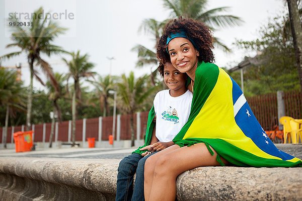 Junge Mutter und Sohn mit brasilianischer Flagge am Strand von Ipanema  Rio De Janeiro  Brasilien