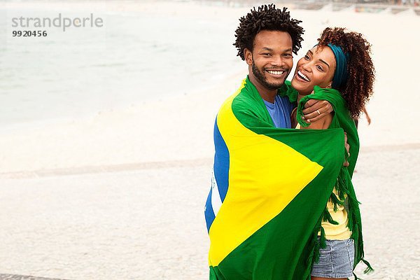 Paarumarmung in brasilianischer Flagge am Strand von Ipanema  Rio De Janeiro  Brasilien