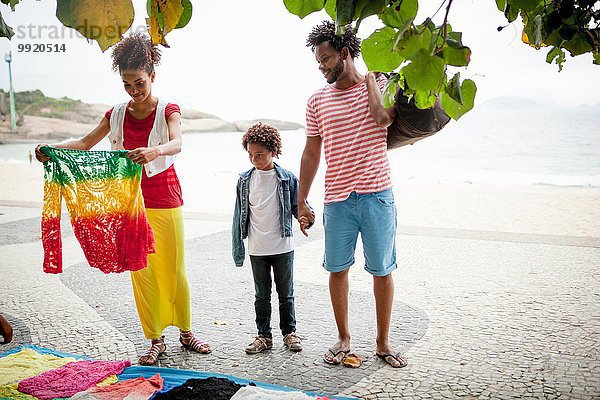 Pärchen und Sohn wählen Pullover vom Bürgersteig  Ipanema Strand  Rio De Janeiro  Brasilien