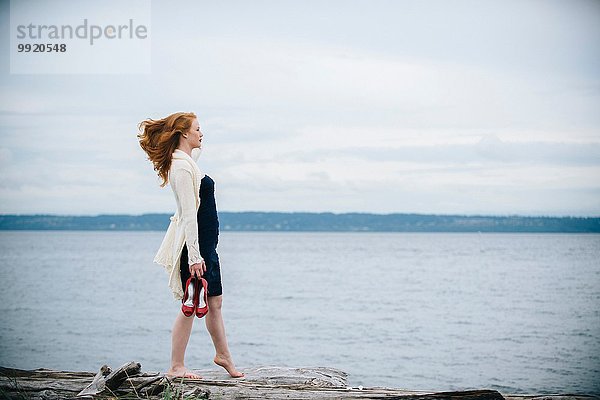 Junge Frau am Strand mit Blick aufs Meer  Bainbridge Island  Washington State  USA