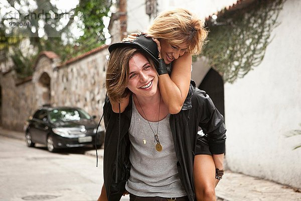 Junger Mann gibt Freundin ein Huckepack auf der Straße  Rio De Janeiro  Brasilien