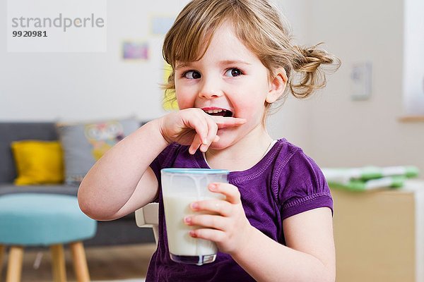 Mädchen mit einem Glas Milch zu Hause