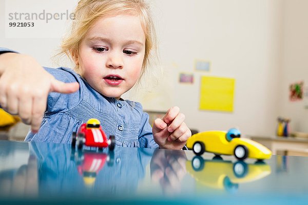 Mädchen spielen mit Spielzeugautos zu Hause