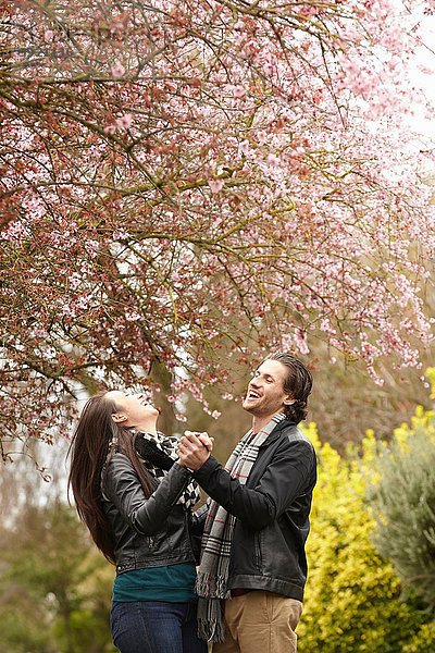 Junges Paar tanzt unter Blüte im Park