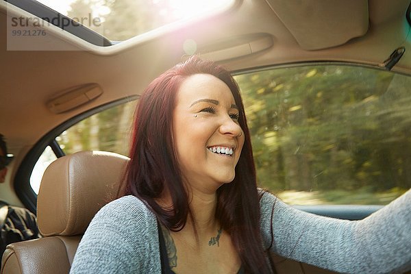 Lächelnde junge Frau beim Autofahren