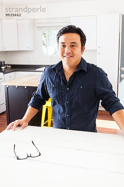 Porträt eines reifen Mannes am Küchentisch
