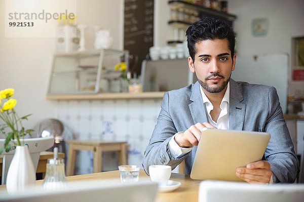 Mann mit digitalem Tablett im Café