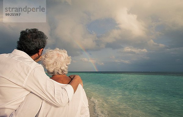 Seniorenpaar mit Blick auf Regenbogen über Meer  Malediven