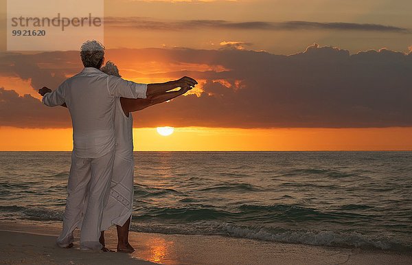 Seniorenpaar am Strand bei Sonnenuntergang