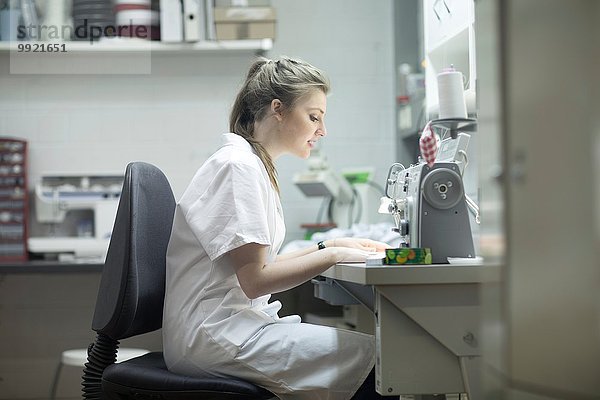 Frau arbeitet an der Nähmaschine in der Wäscherei