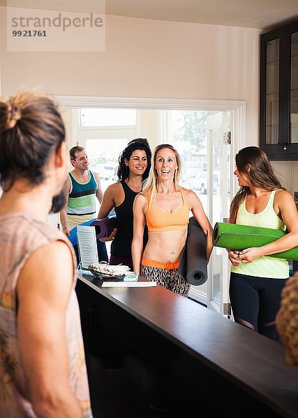 Mittlere erwachsene Frau bei der Ankunft in der Yoga-Klasse