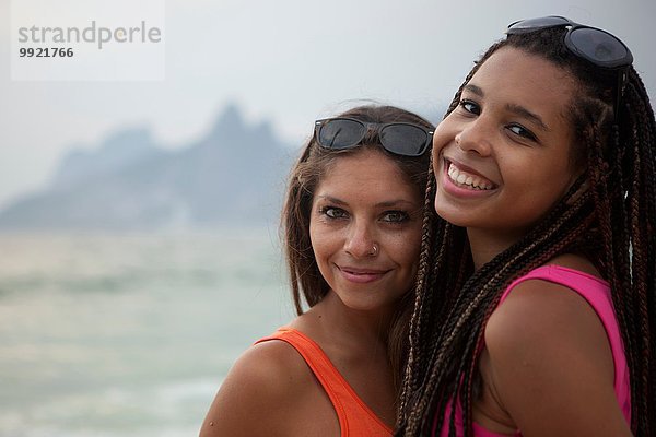 Porträt von zwei lächelnden jungen Frauen am Strand von Ipanema  Rio De Janeiro  Brasilien
