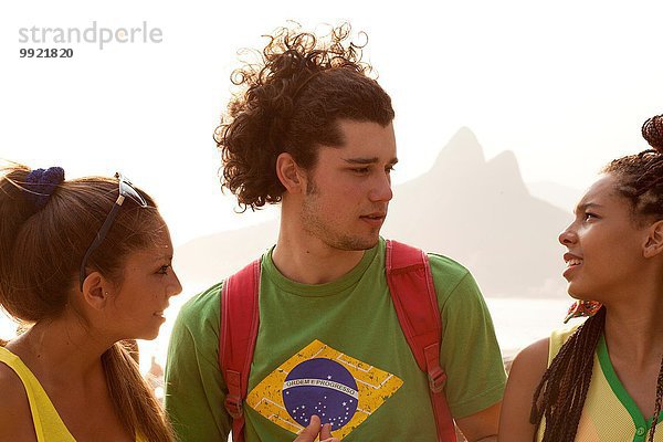 Drei junge erwachsene Freunde beim Plaudern am Strand von Ipanema  Rio De Janeiro  Brasilien