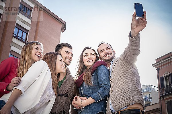 Mittlerer Erwachsener Mann  der Smartphone Selfie mit Freunden auf der Straße nimmt  Cagliari  Sardinien  Italien