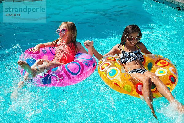 Mädchen in aufblasbaren Ringen im Schwimmbad