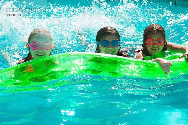 Mädchen mit aufblasbarem Spielzeug im Schwimmbad