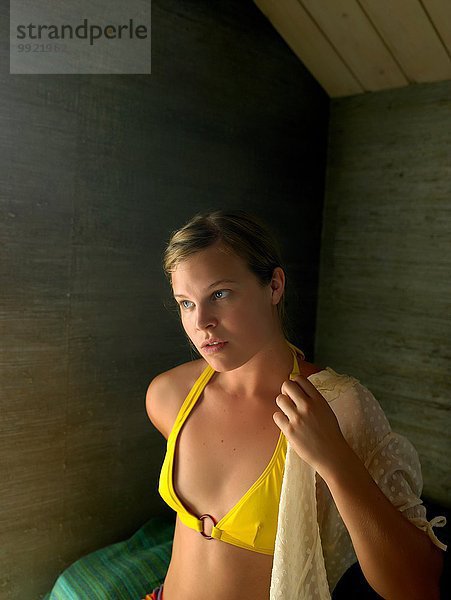 Porträt einer jungen Frau  die eine Bluse über dem Bikini trägt