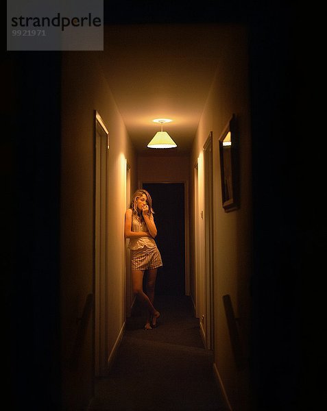 Porträt eines jungen Mädchens allein im dunklen Korridor