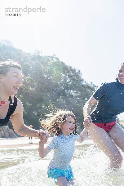 Zwei Frauen und ein Mädchen laufen ins Meer  Hot Water Beach  Bay of Islands  Neuseeland