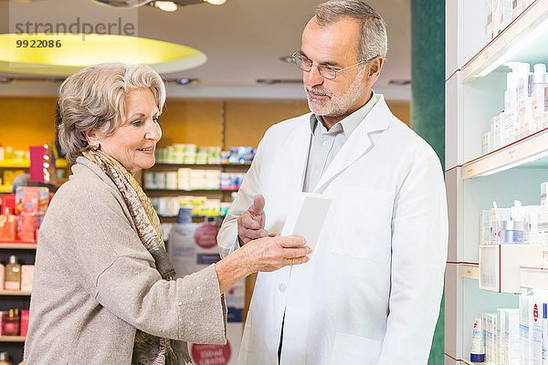 Apothekerin berät Seniorin in der Medizin in der Apotheke