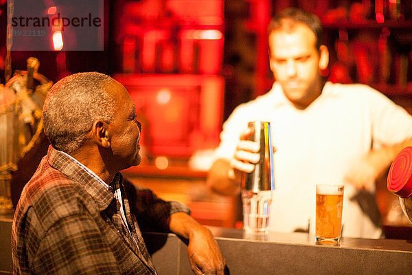 Senior Mann im Gespräch mit Barmann an der Cocktailbar  Rio De Janeiro  Brasilien