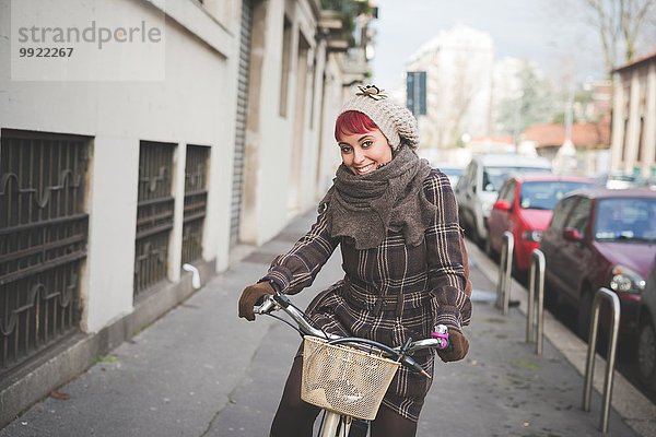 Portrait einer jungen Frau  die Fahrrad fährt und Winterkleidung trägt.