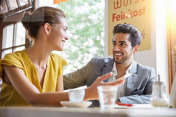 Junges Paar im Cafe sitzend  sprechend  Blickwinkel niedrig