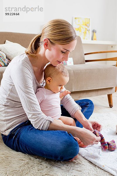 Mutter zieht Socken an Baby Girl