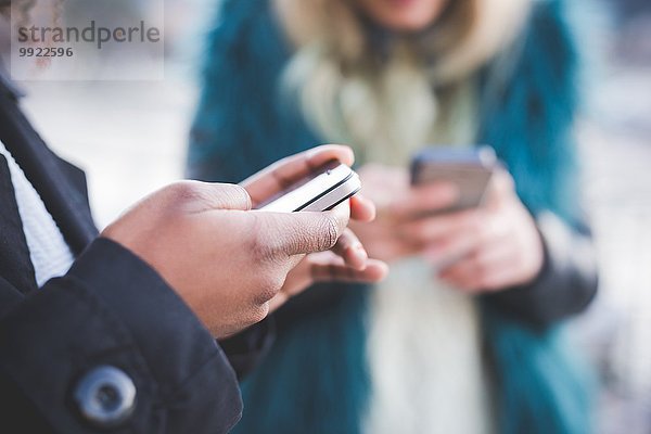 Nahaufnahme von zwei jungen Frauen auf Smartphones  Comer See  Comer See  Italien