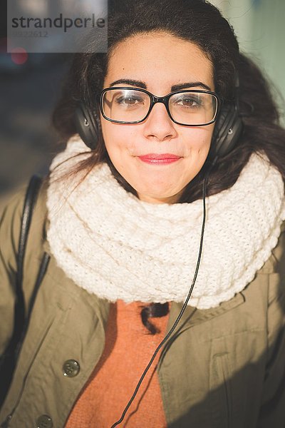 Nahaufnahme des Porträts einer jungen Frau  die eine Brille auf der Straße schwört.