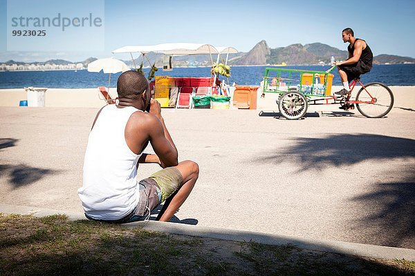 Mann beobachtet Wasserverkäufer auf dem Fahrrad