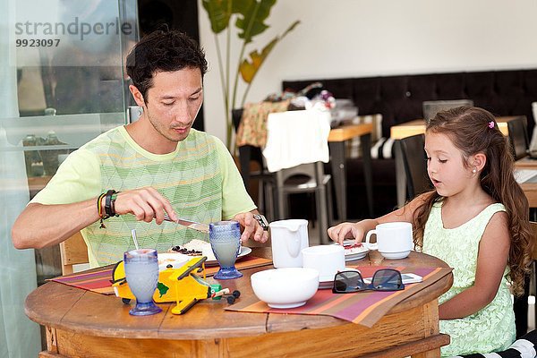 Vater und Tochter sitzen zusammen am Frühstückstisch