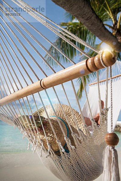 Junge Frau entspannt auf einer Hängematte auf einer tropischen Insel