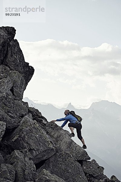 Erwachsener Mann klettert auf Felsen  Wallis  Schweiz