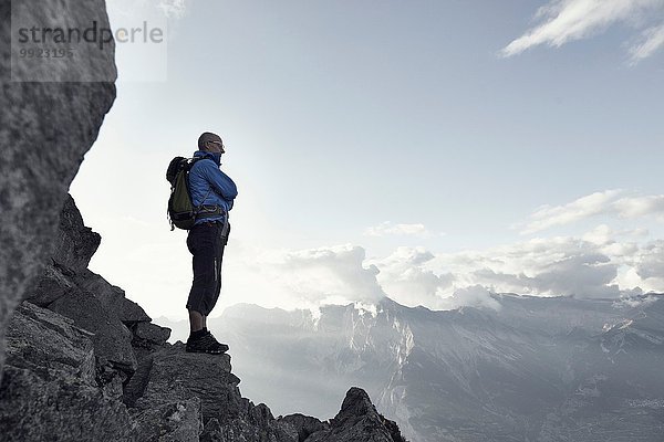 Erwachsener Mann auf Felsen stehend  Wallis  Schweiz