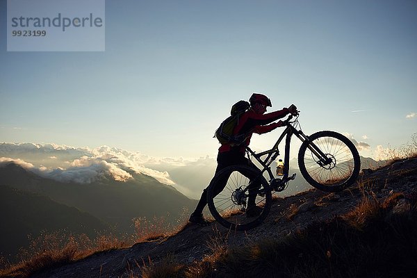Mountainbiker schieben Fahrrad bergauf  Wallis  Schweiz