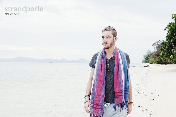 Junger Mann beim Bummeln am Strand  Kradan  Thailand