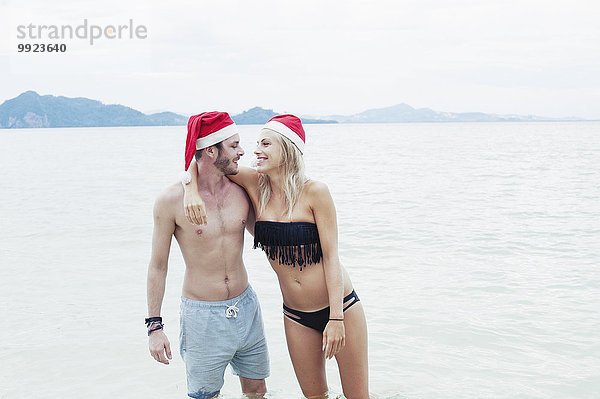 Junges Paar mit Weihnachtsmützen am Strand  Kradan  Thailand